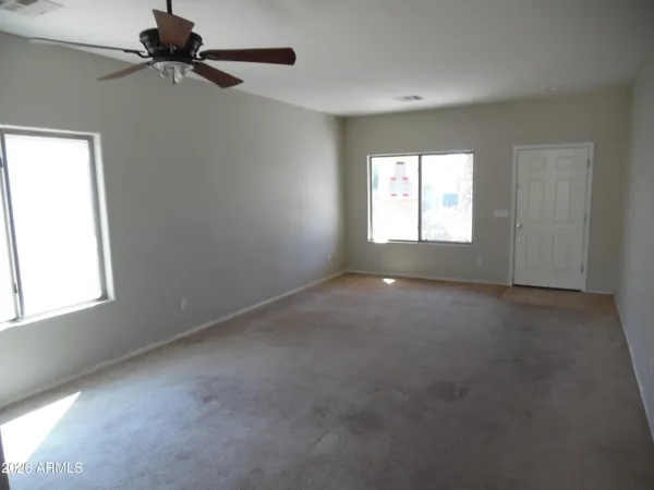an empty room with a window and a fan