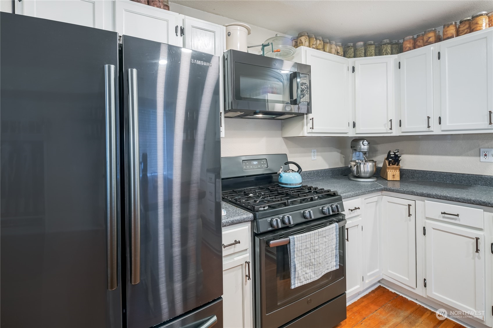 402 West 3rd Street Nooksack, WA 98276 - Photo 23 of 36 a kitchen with stainless steel appliances granite countertop a refrigerator stove and white cabinets