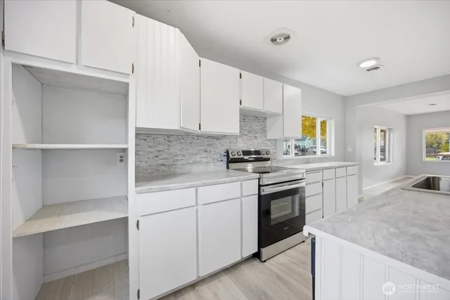 a kitchen with white cabinets and appliances