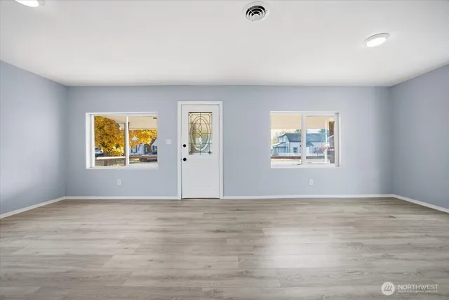 a view of an empty room with wooden floor