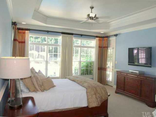 604 Mason Road Durham, NC 27712 - Photo 12 of 25 a bedroom with a large bed and a chandelier