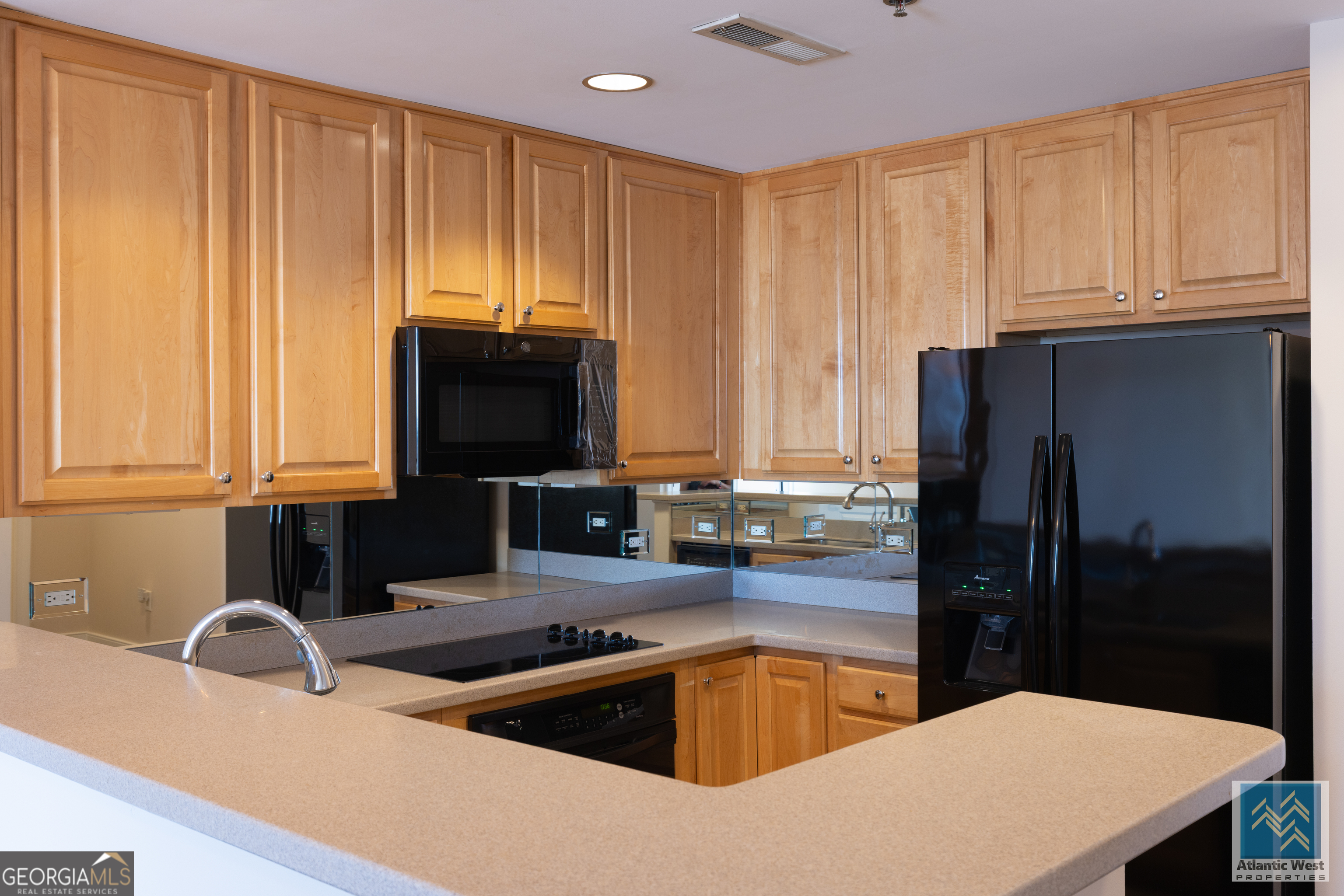 285 Centennial Olympic Park Drive Northwest, Unit 1106 Atlanta, GA 30313 - Photo 12 of 44 a kitchen with a refrigerator and a sink