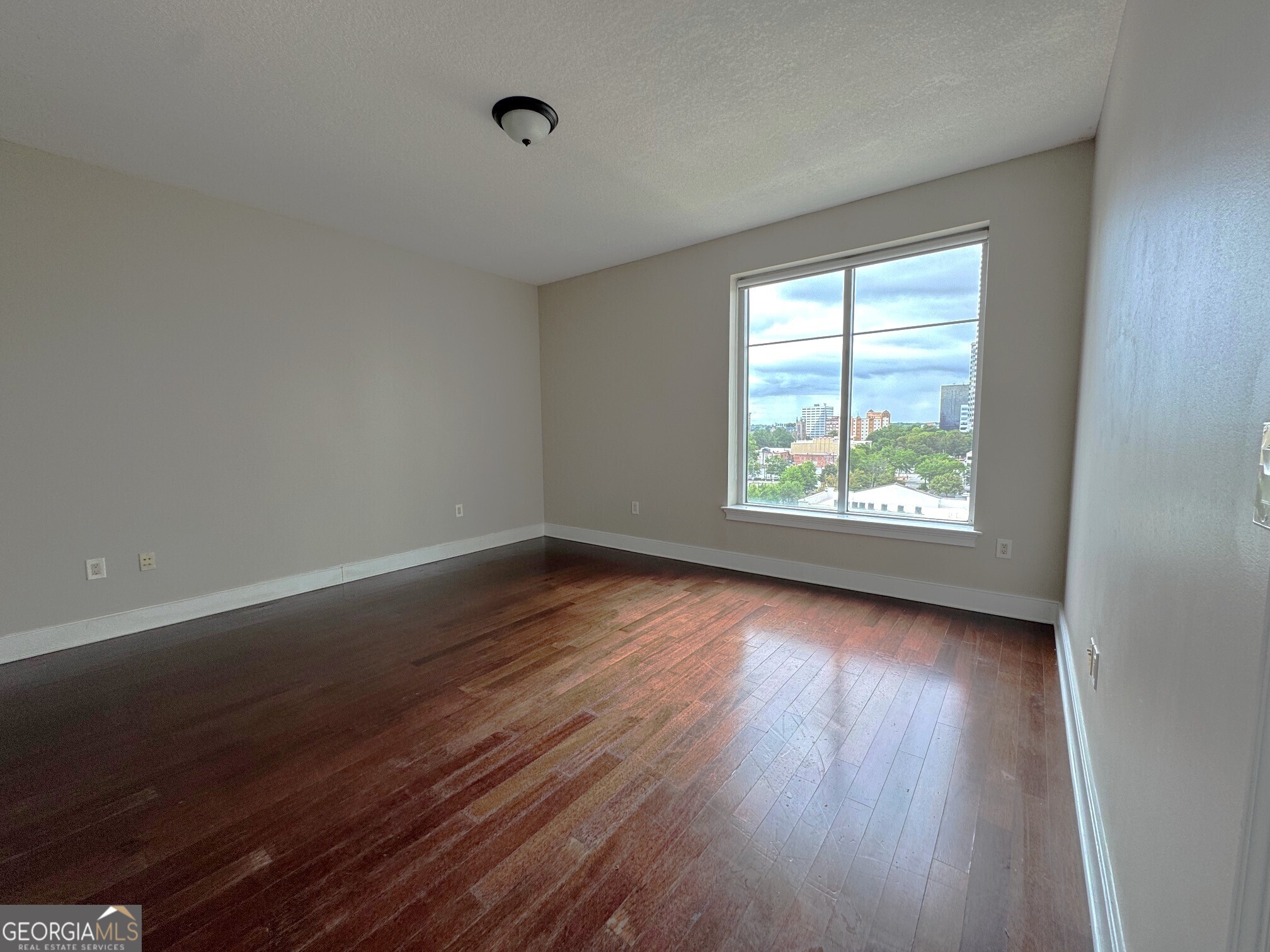 285 Centennial Olympic Park Drive Northwest, Unit 1106 Atlanta, GA 30313 - Photo 21 of 44 an empty room with wooden floor and windows