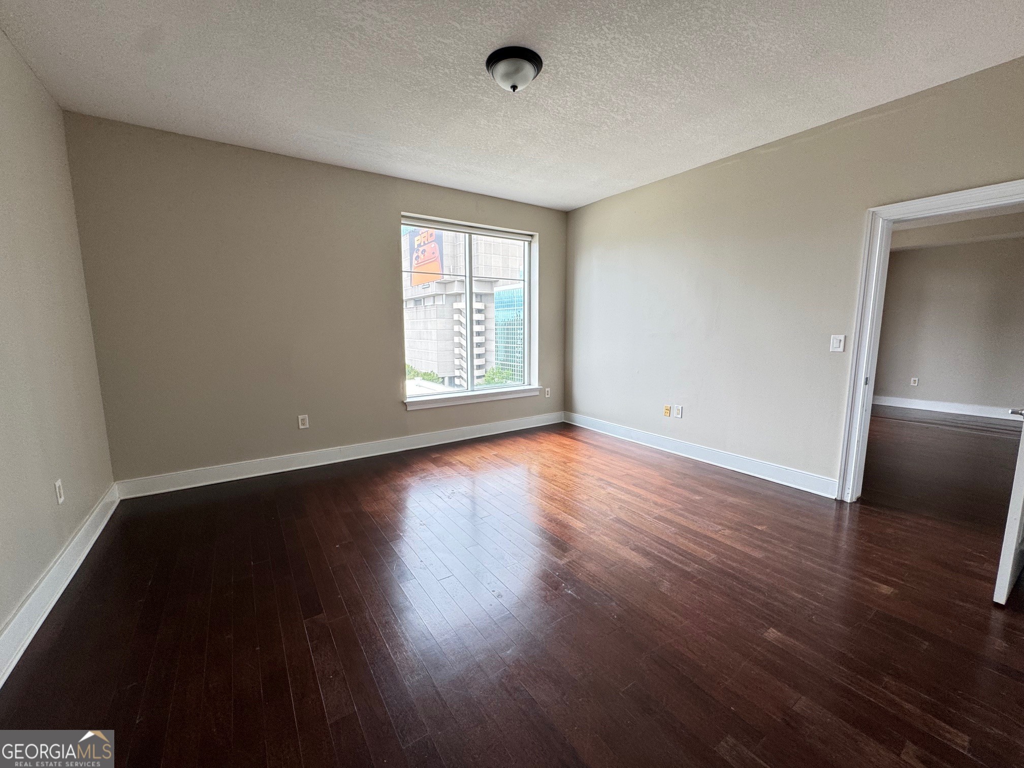 285 Centennial Olympic Park Drive Northwest, Unit 1106 Atlanta, GA 30313 - Photo 22 of 44 a view of an empty room with wooden floor and a window
