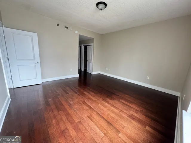 a view of an empty room with wooden floor