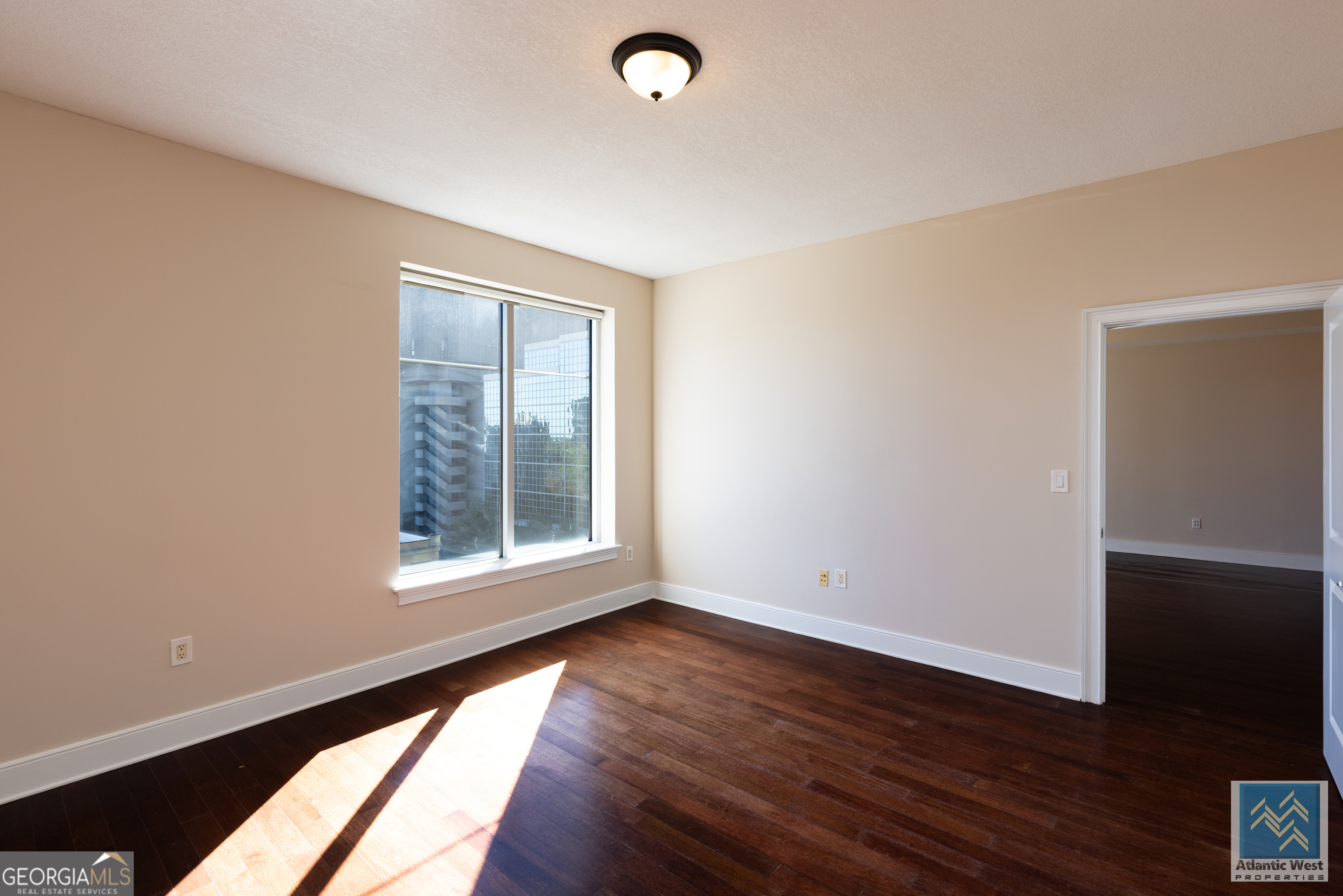 285 Centennial Olympic Park Drive Northwest, Unit 1106 Atlanta, GA 30313 - Photo 24 of 44 an empty room with wooden floor and windows