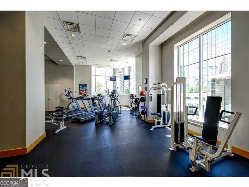 285 Centennial Olympic Park Drive Northwest, Unit 1106 Atlanta, GA 30313 - Photo 34 of 44 a view of a room with gym equipment and a large window
