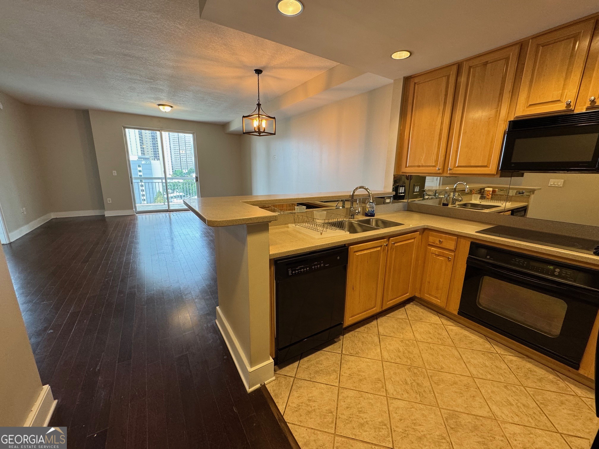 285 Centennial Olympic Park Drive Northwest, Unit 1106 Atlanta, GA 30313 - Photo 4 of 44 a kitchen with stainless steel appliances granite countertop a stove a sink and a microwave