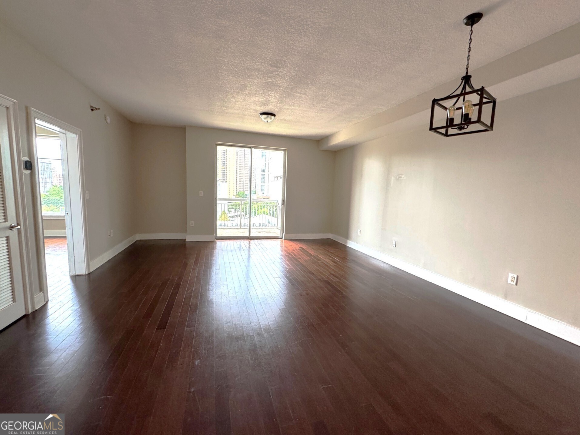 285 Centennial Olympic Park Drive Northwest, Unit 1106 Atlanta, GA 30313 - Photo 5 of 44 a view of an empty room with wooden floor and a window