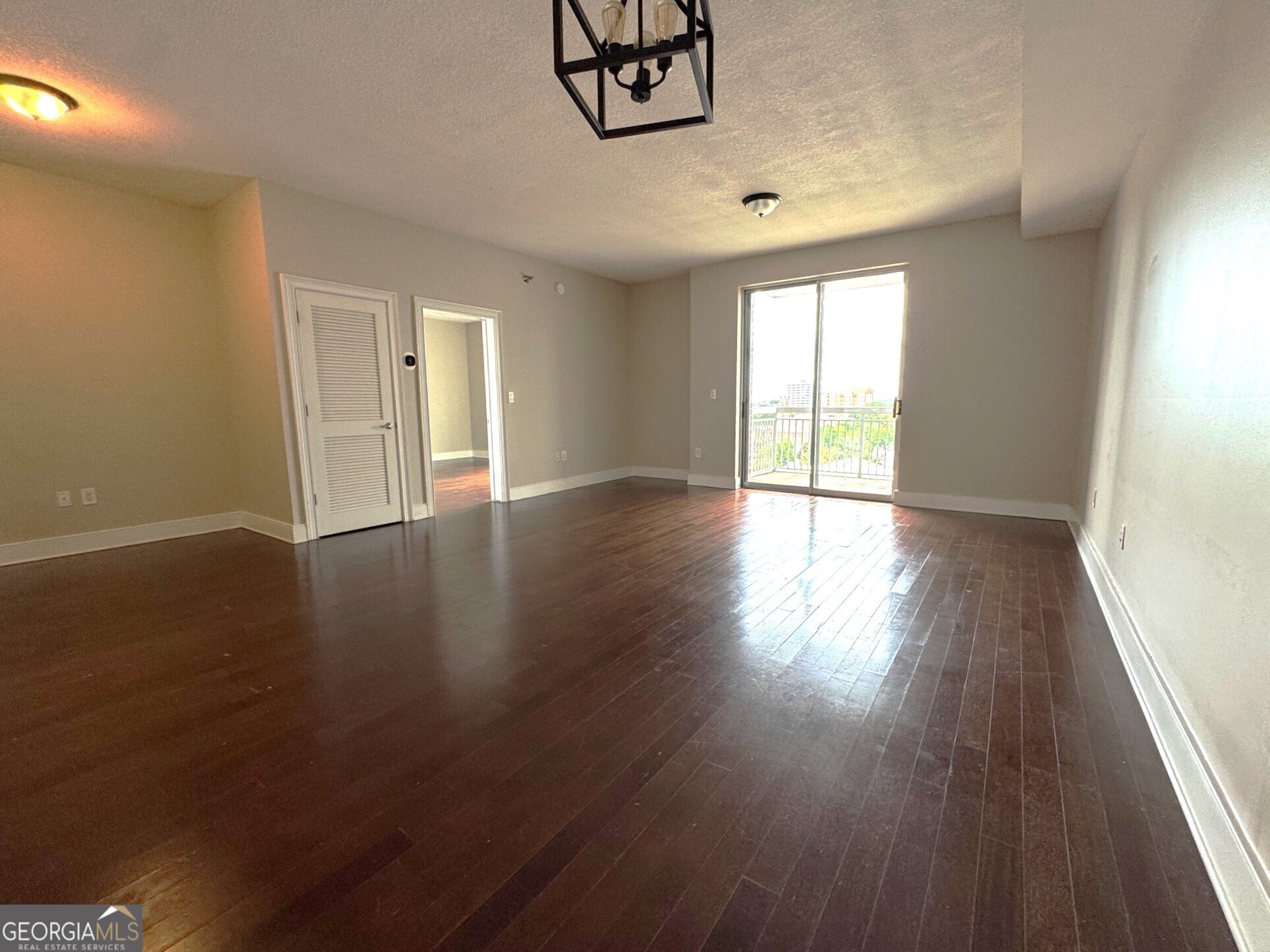 285 Centennial Olympic Park Drive Northwest, Unit 1106 Atlanta, GA 30313 - Photo 7 of 44 an empty room with wooden floor and windows