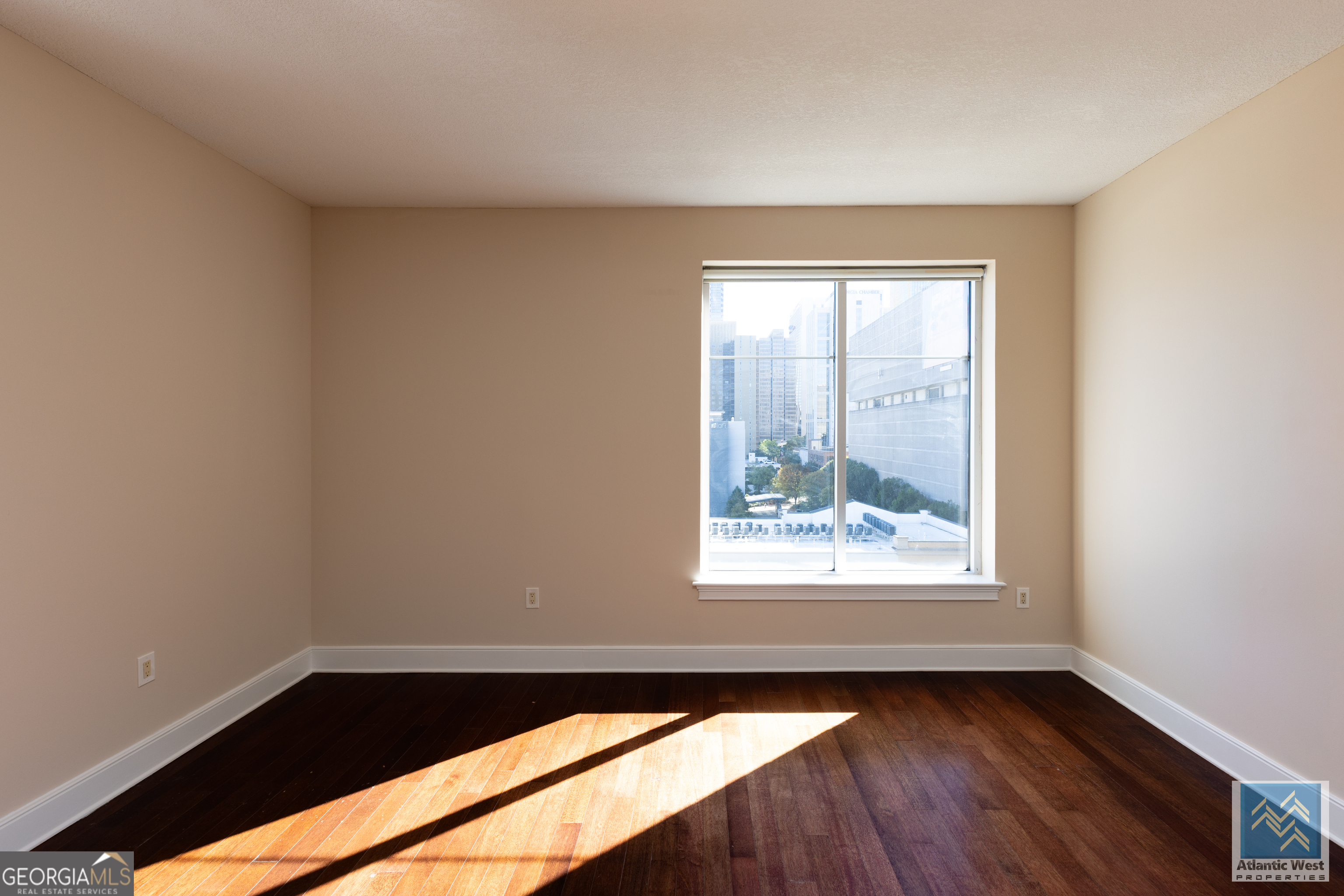 285 Centennial Olympic Park Drive Northwest, Unit 1106 Atlanta, GA 30313 - Photo 9 of 44 an empty room with wooden floor and windows