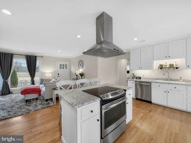 a kitchen with granite countertop a sink stainless steel appliances and cabinets