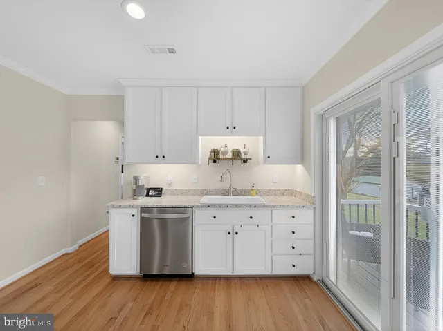 a kitchen with a sink cabinets and wooden floor