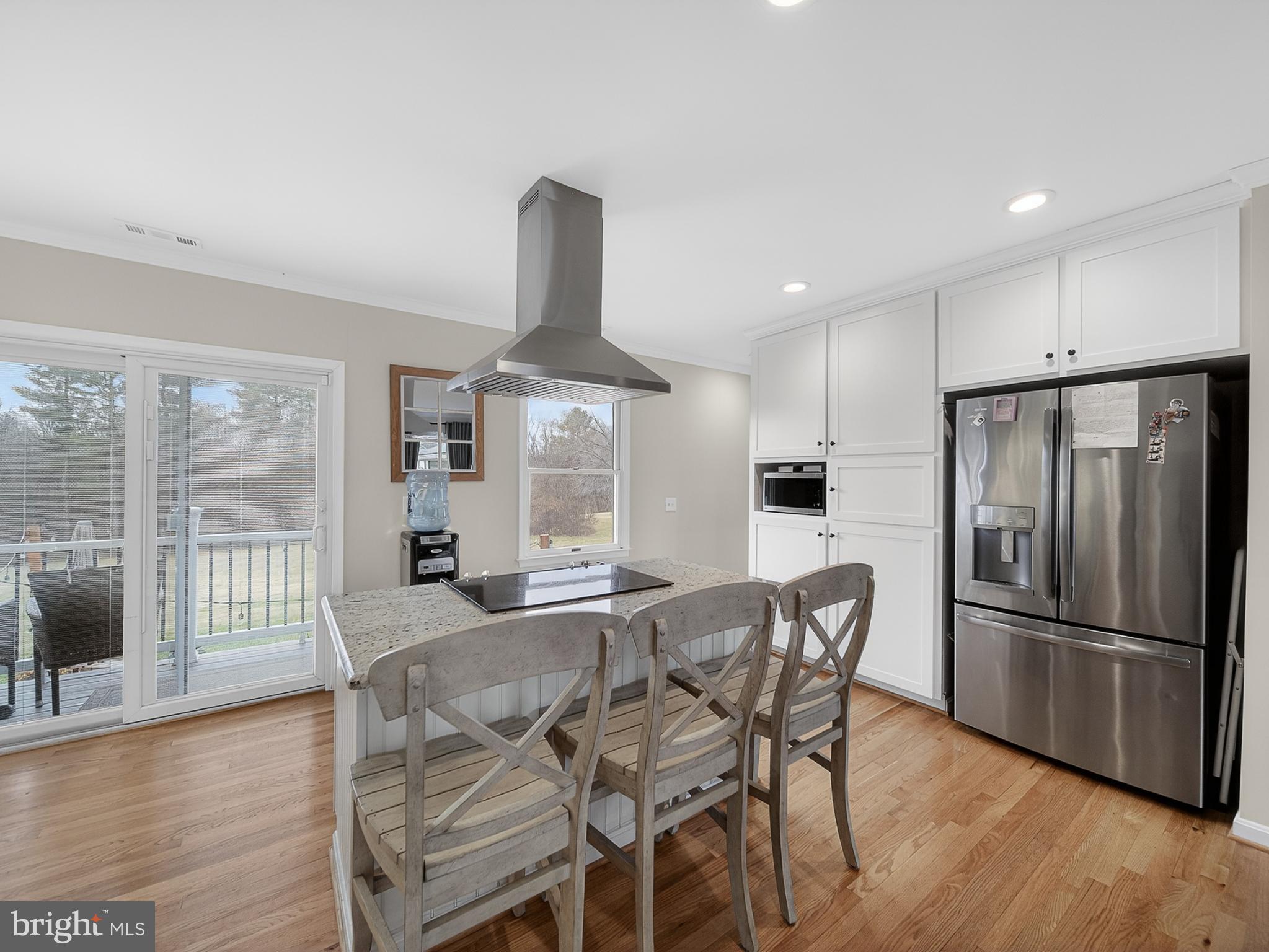 8746 Meetze Road Warrenton, VA 20187 - Photo 16 of 48 a kitchen with stainless steel appliances a refrigerator a stove a dining table and chairs with wooden floor