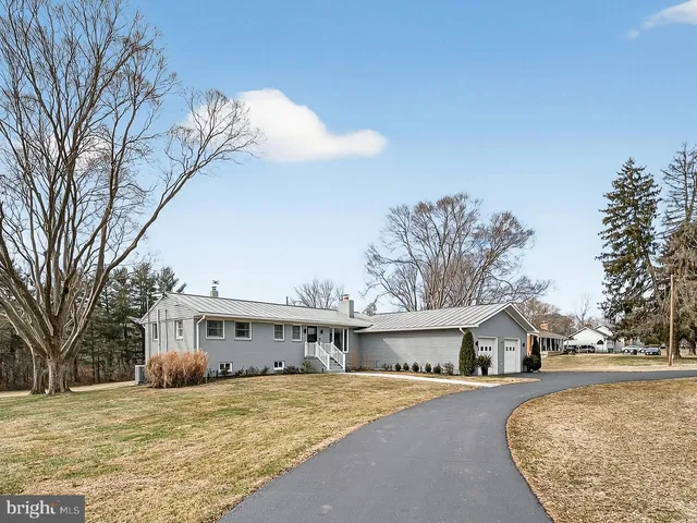 a front view of a house with yard yard and trees