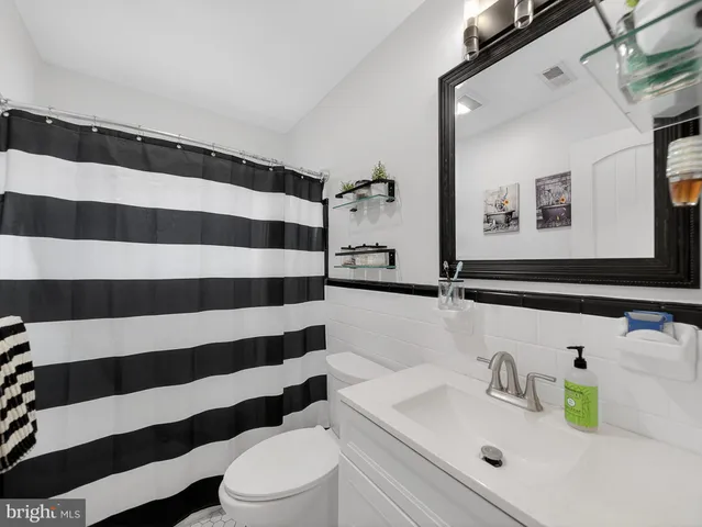 a bathroom with a sink a toilet and a mirror