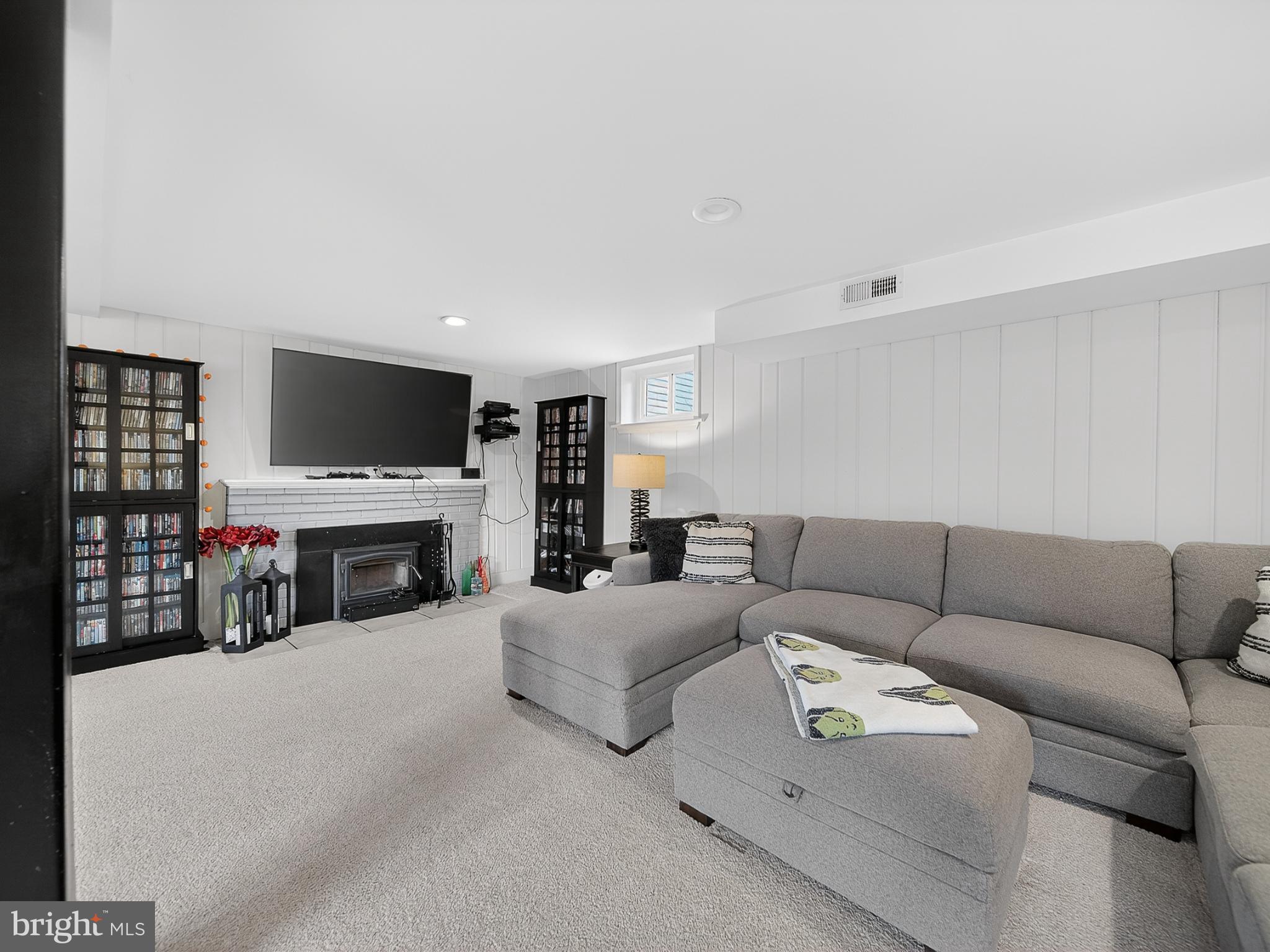 8746 Meetze Road Warrenton, VA 20187 - Photo 34 of 48 a living room with furniture a fireplace and a flat screen tv