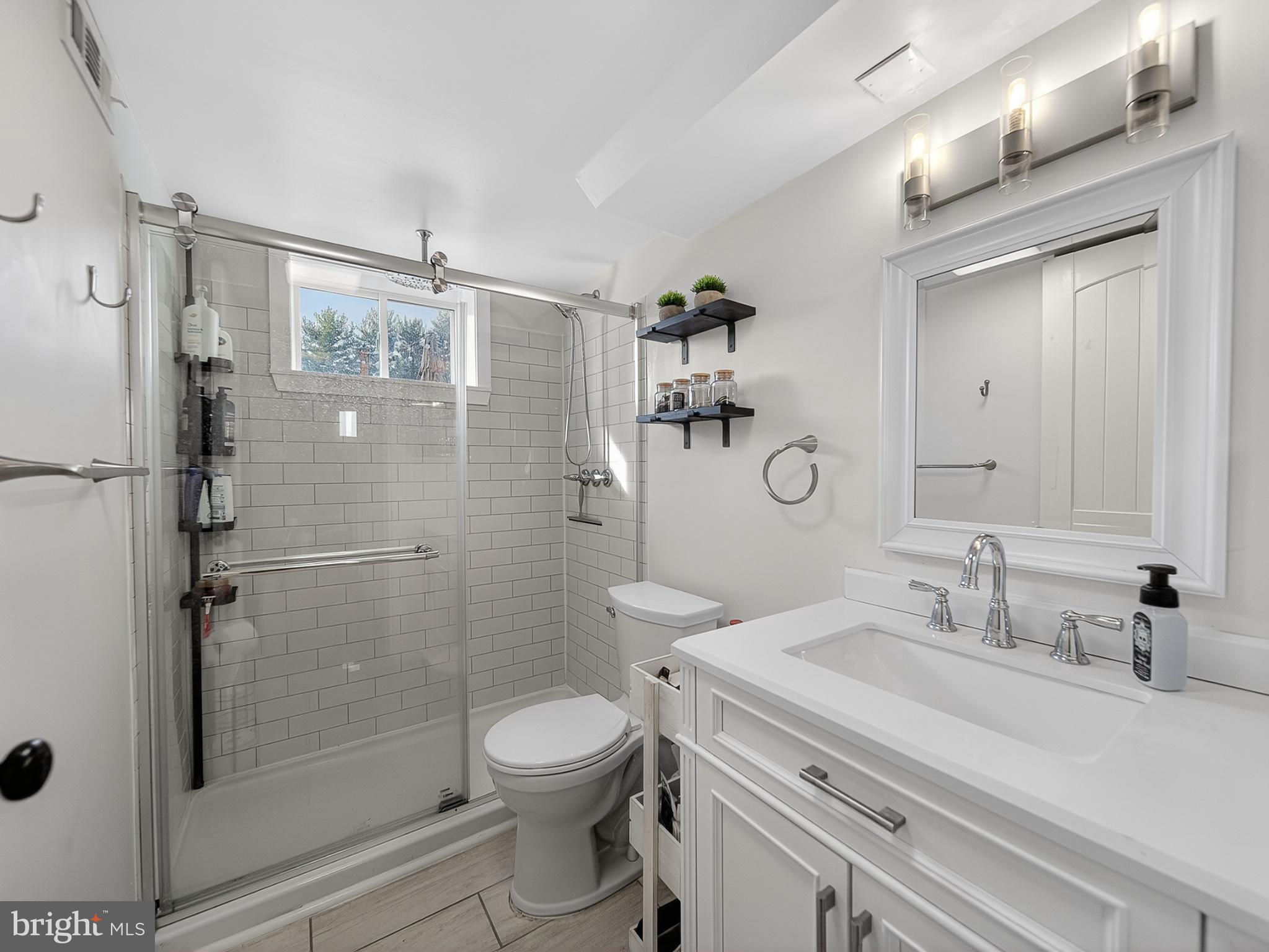 8746 Meetze Road Warrenton, VA 20187 - Photo 41 of 48 a bathroom with a granite countertop shower a mirror a toilet and a sink