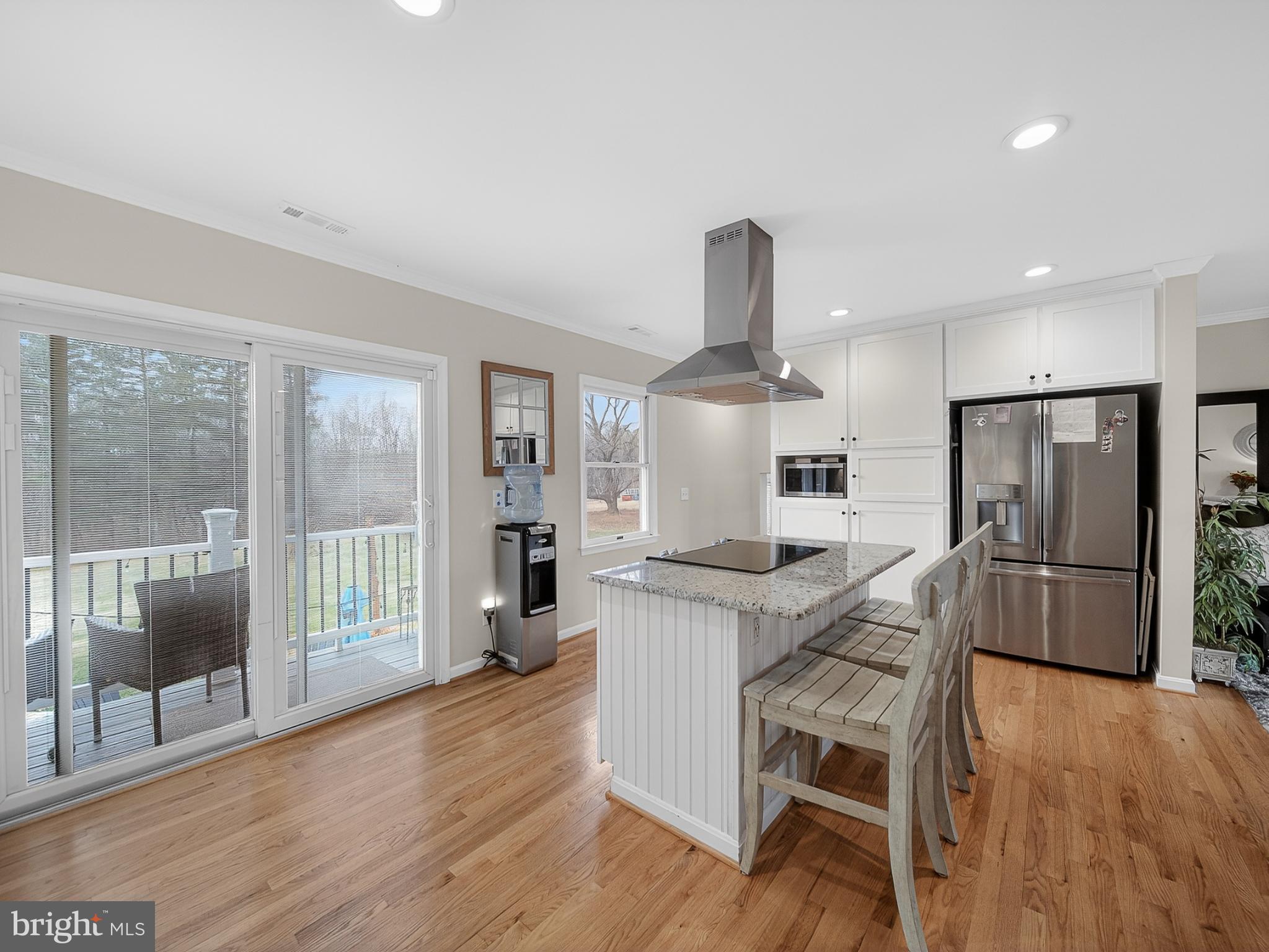 8746 Meetze Road Warrenton, VA 20187 - Photo 10 of 48 a kitchen with stainless steel appliances a dining table chairs and wooden floors