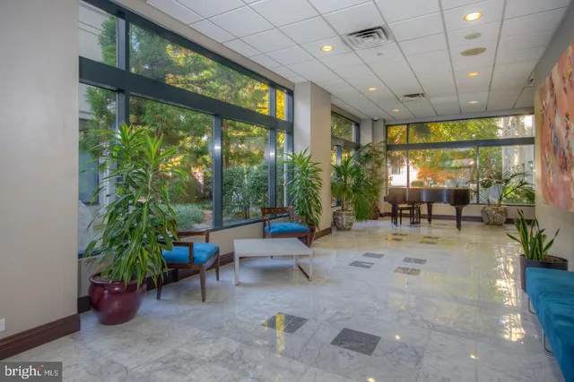 a living room with patio furniture and a potted plant