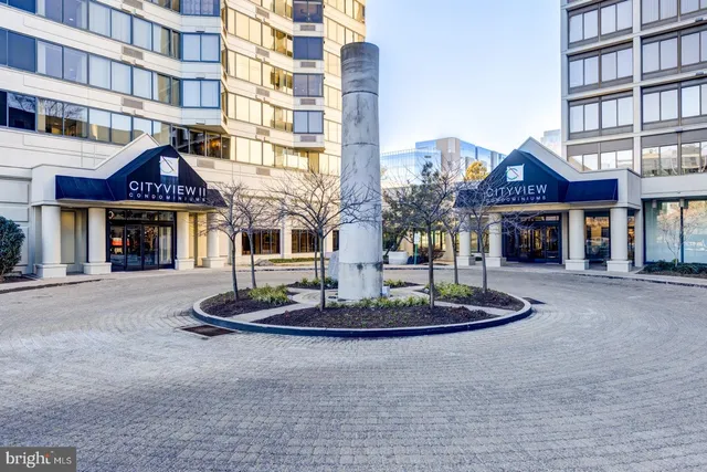 a front view of a building with a garden and plants