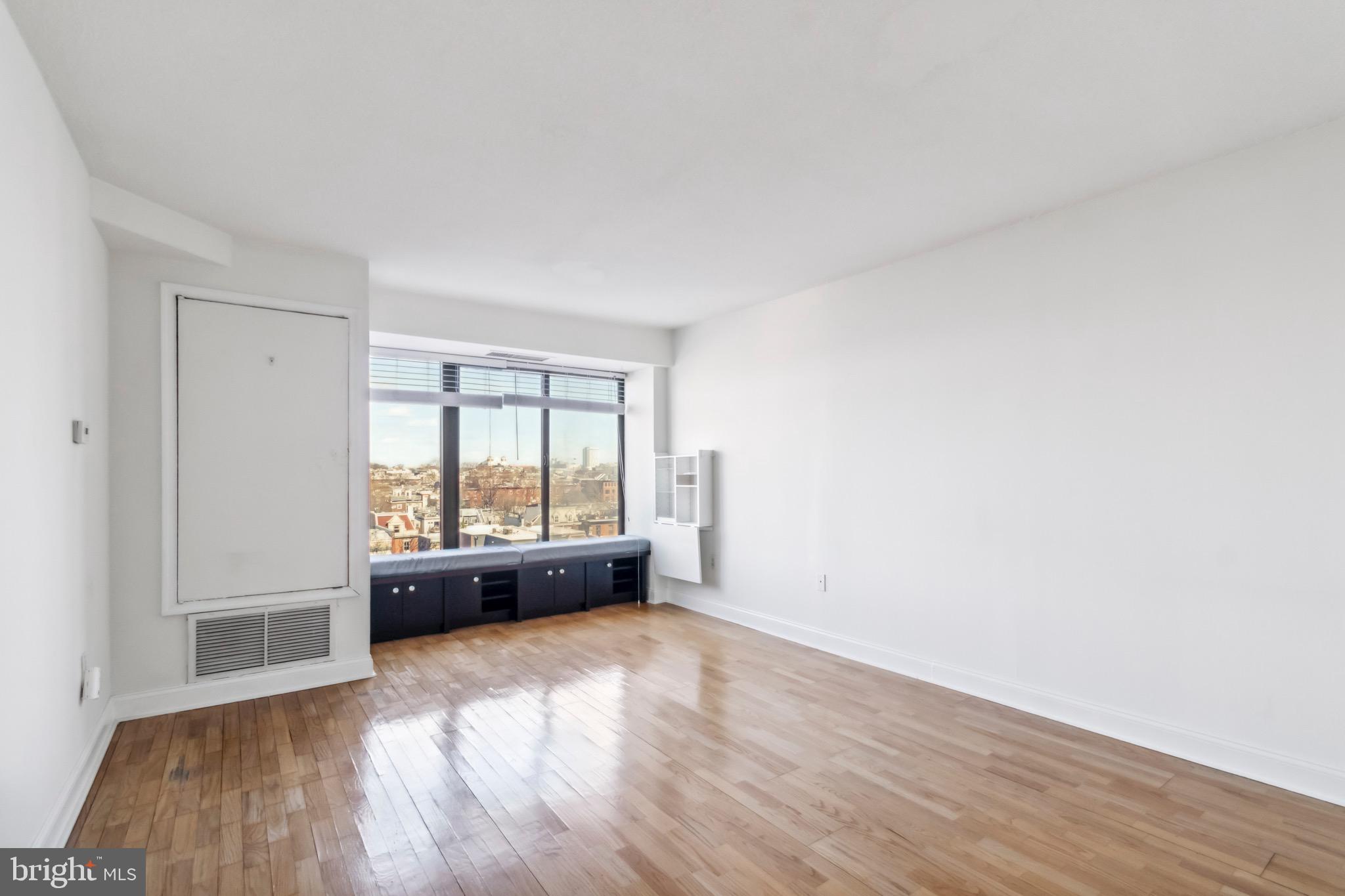 2001 Hamilton Street, Unit 927 Philadelphia, PA 19130 - Photo 4 of 26 an empty room with wooden floor and windows