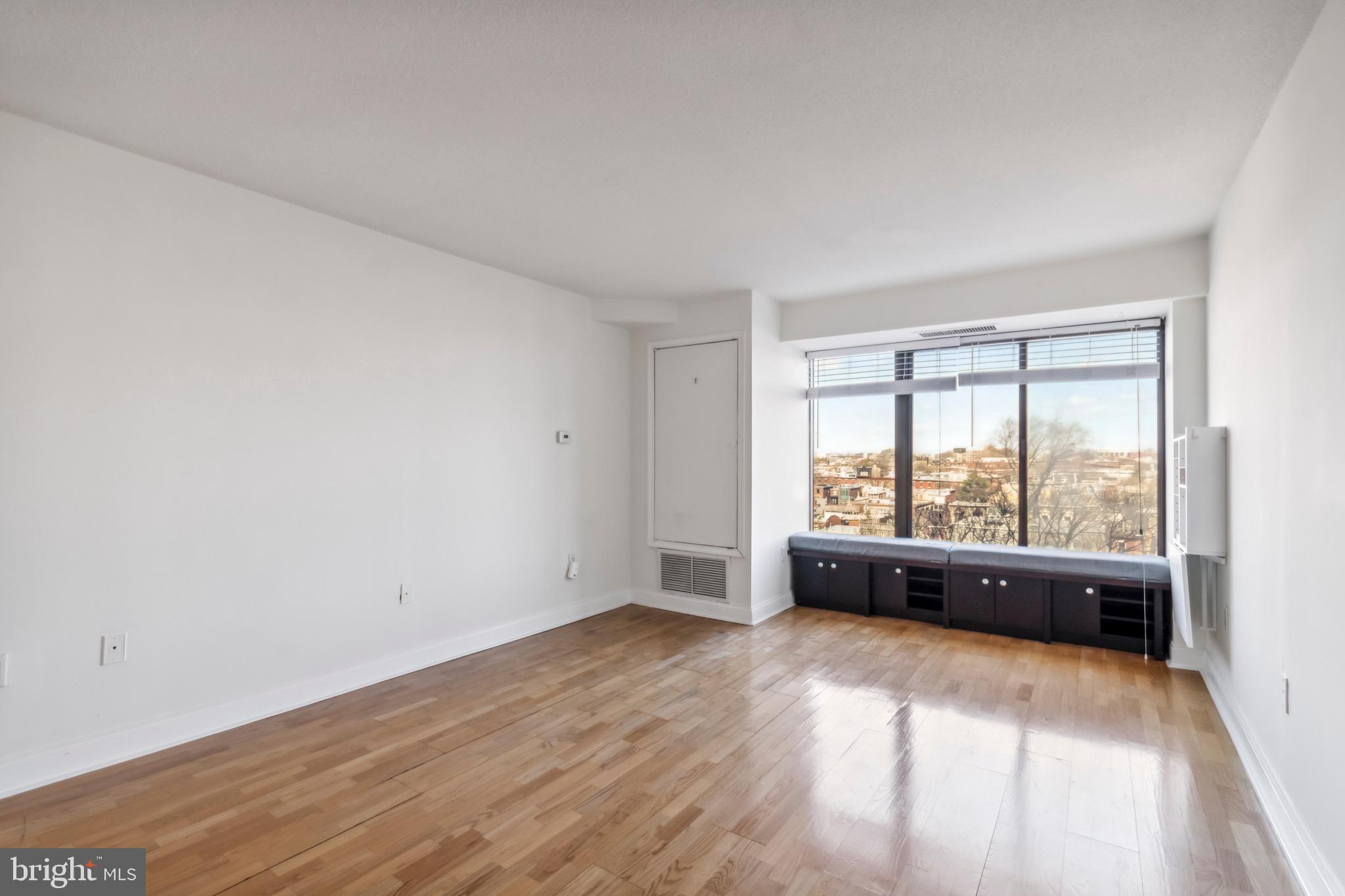 2001 Hamilton Street, Unit 927 Philadelphia, PA 19130 - Photo 7 of 26 an empty room with wooden floor and windows