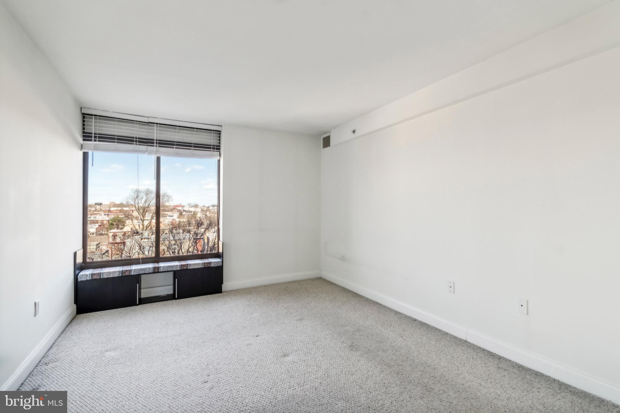 2001 Hamilton Street, Unit 927 Philadelphia, PA 19130 - Photo 10 of 26 an empty room with a fireplace and large windows