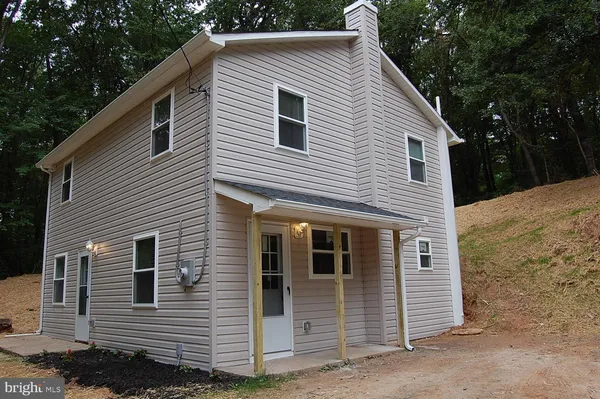 a view of a house and that has a car park side of it