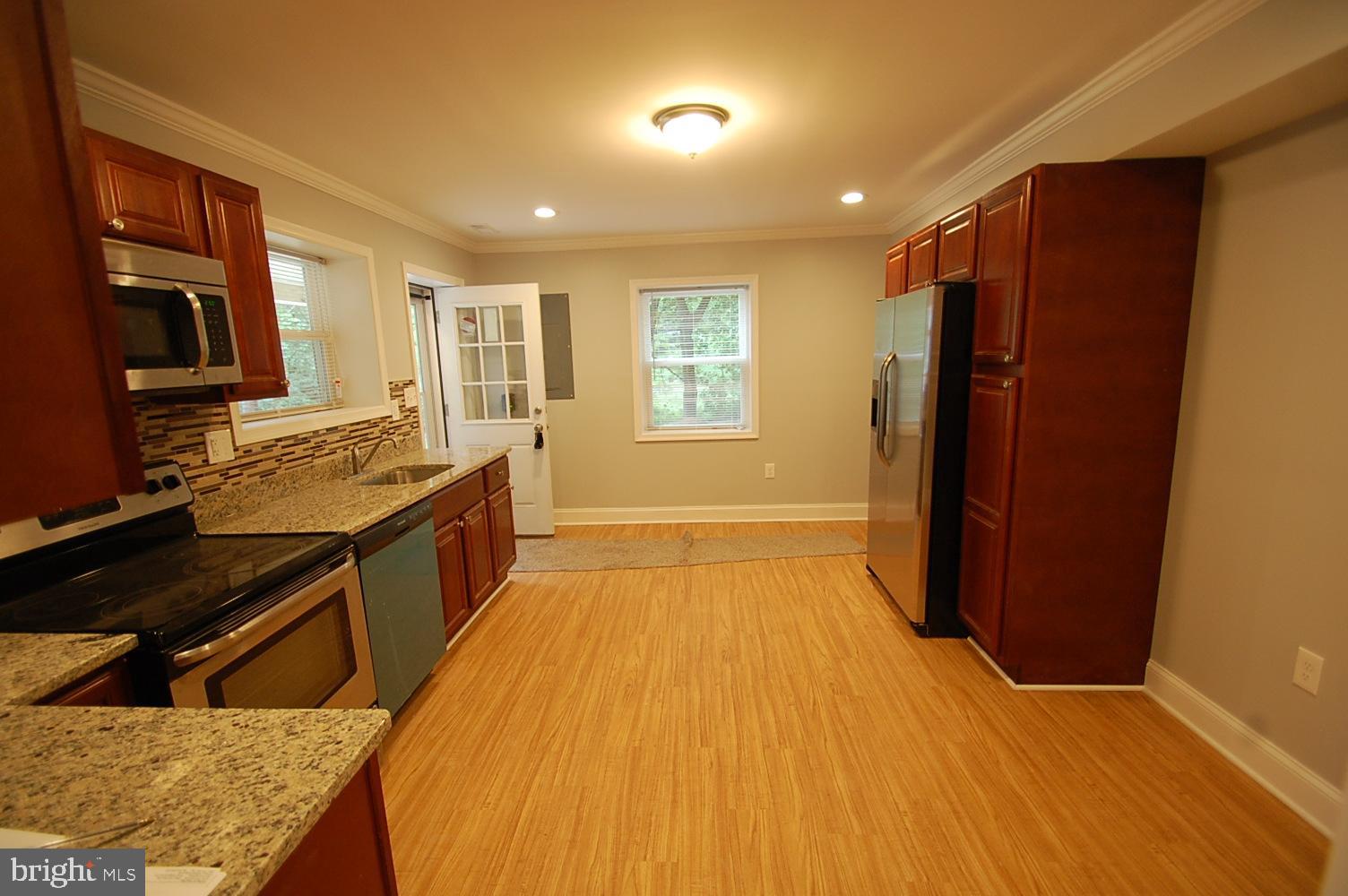 1940 Nelson Mill Road Jarrettsville, MD 21084 - Photo 3 of 8 a kitchen with stainless steel appliances granite countertop a refrigerator a stove and wooden cabinets