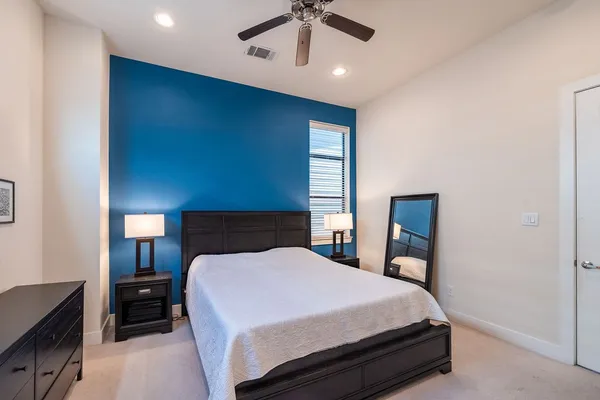 a bed sitting in a bedroom and night stand