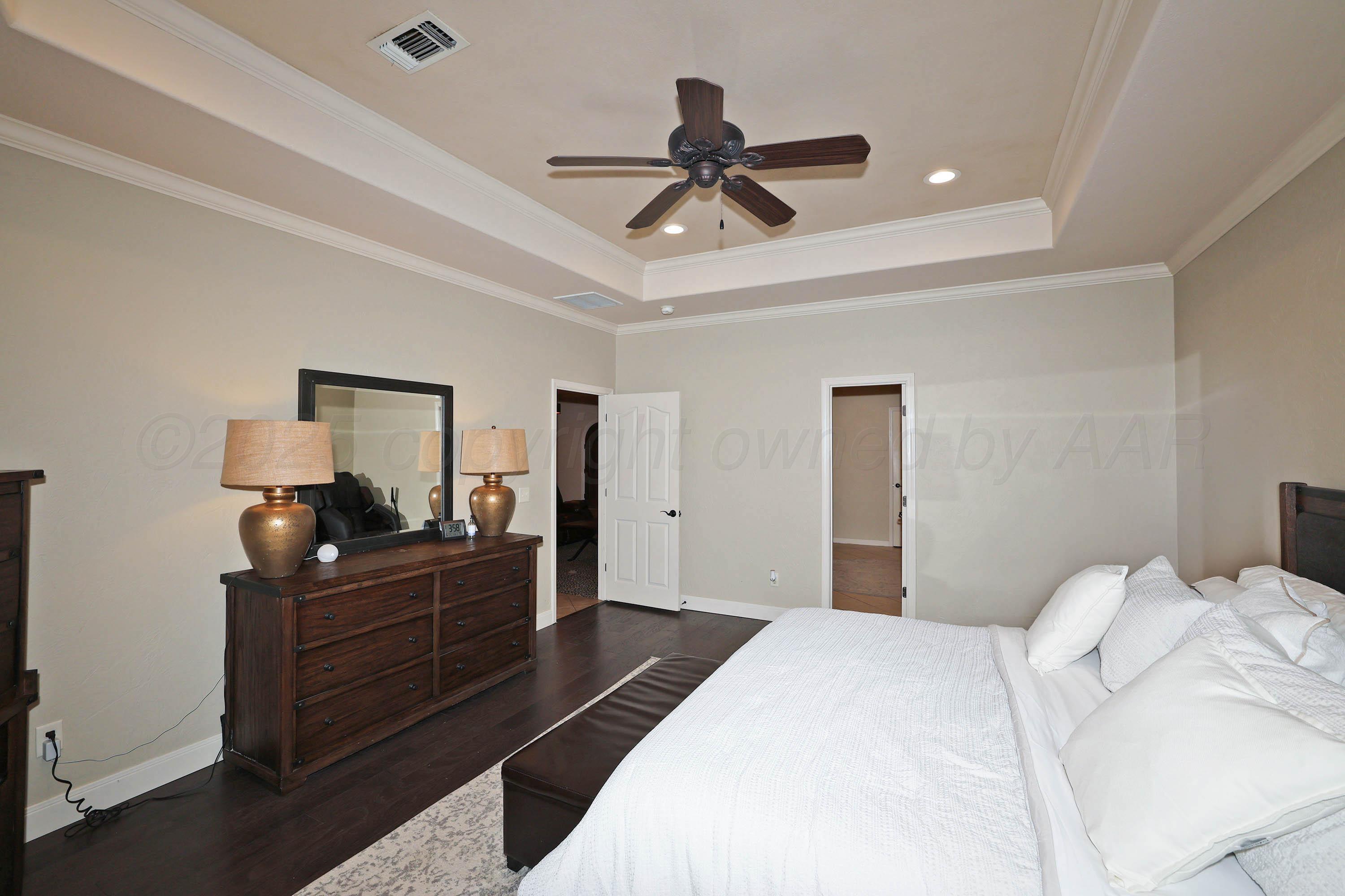 9220 Greyhawk Road Amarillo, TX 79119 - Photo 19 of 50 a bedroom with a bed and a chandelier