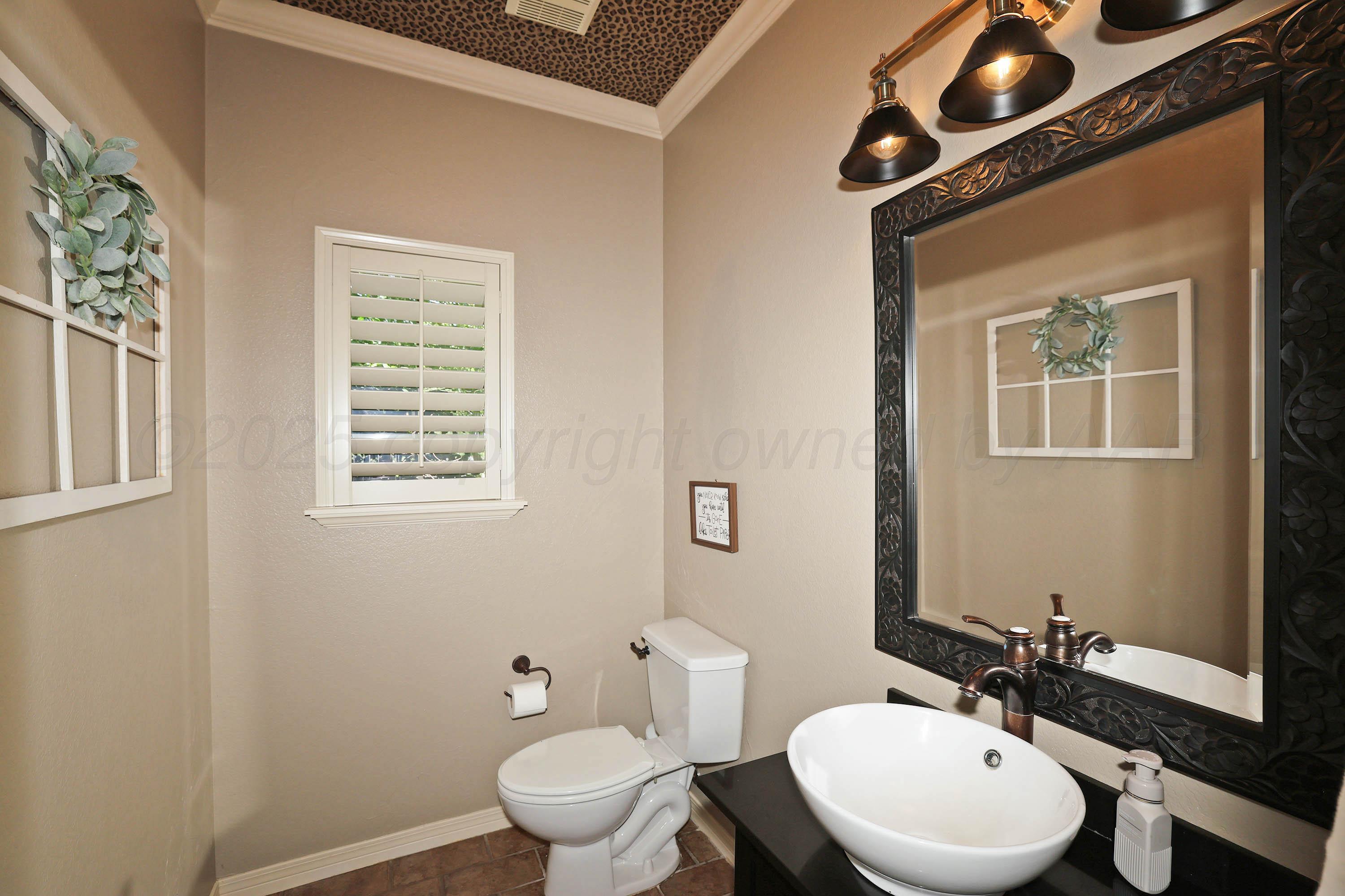 9220 Greyhawk Road Amarillo, TX 79119 - Photo 36 of 50 a bathroom with a granite countertop toilet sink and mirror