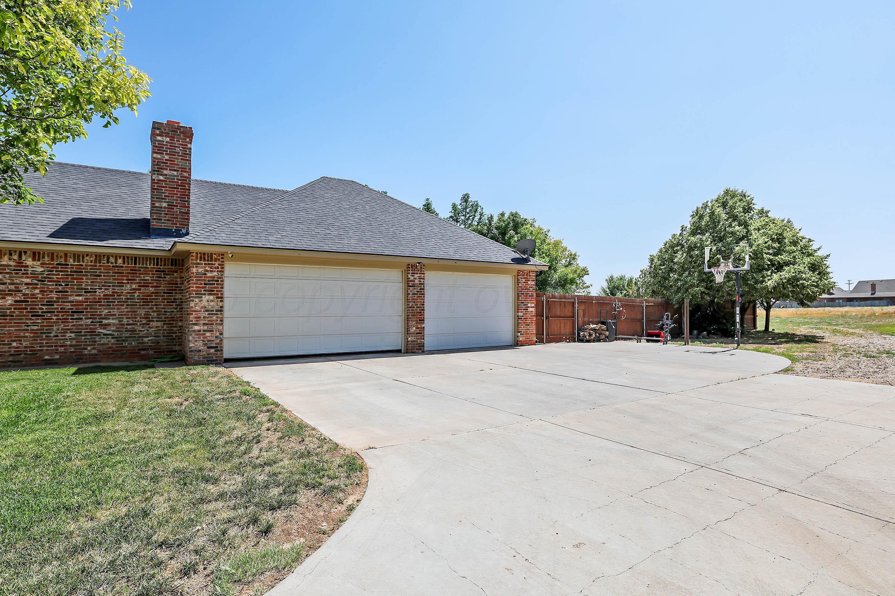 9220 Greyhawk Road Amarillo, TX 79119 - Photo 47 of 50 a front view of a house with a yard and garage