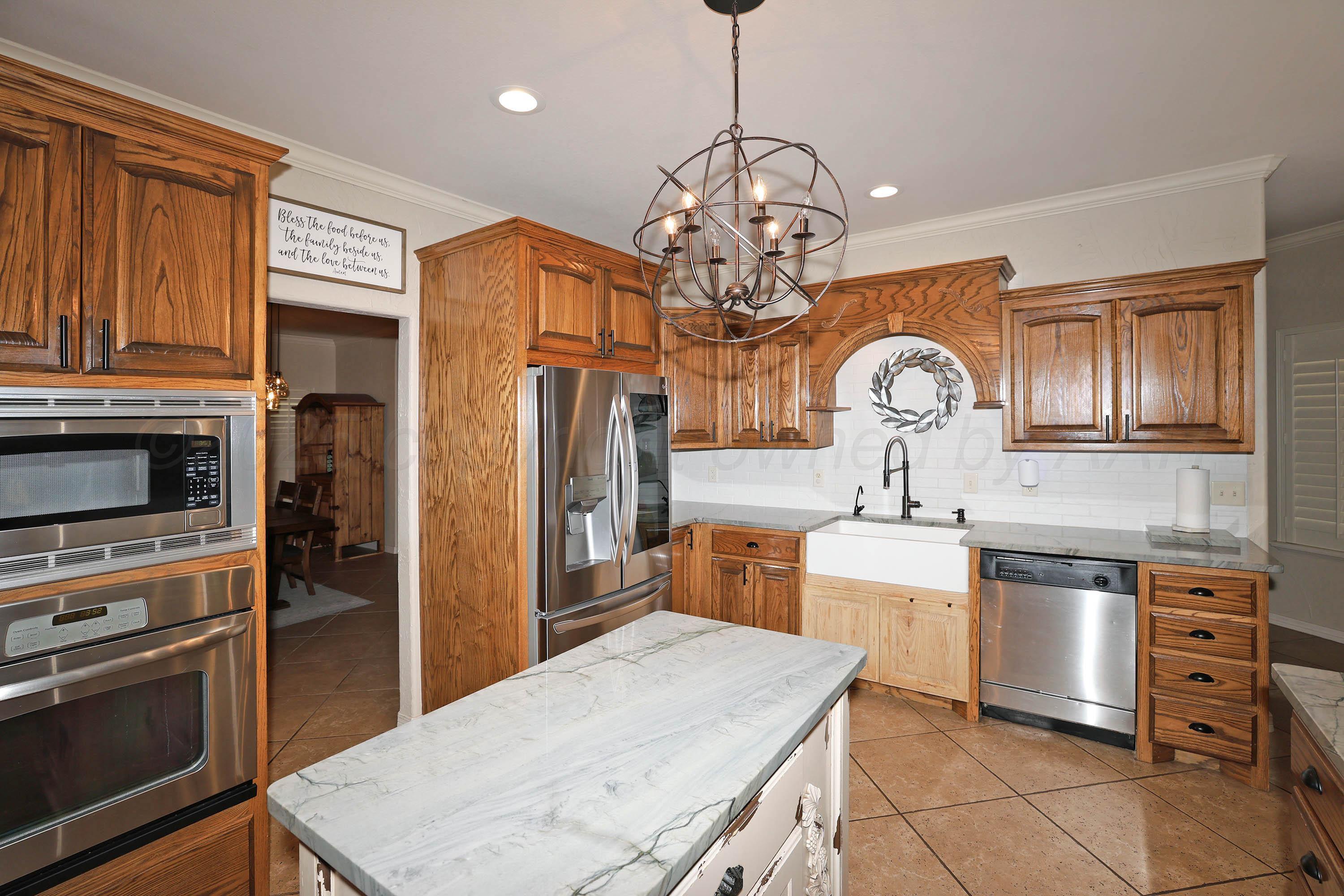 9220 Greyhawk Road Amarillo, TX 79119 - Photo 7 of 50 a kitchen with stainless steel appliances granite countertop a stove refrigerator and cabinets