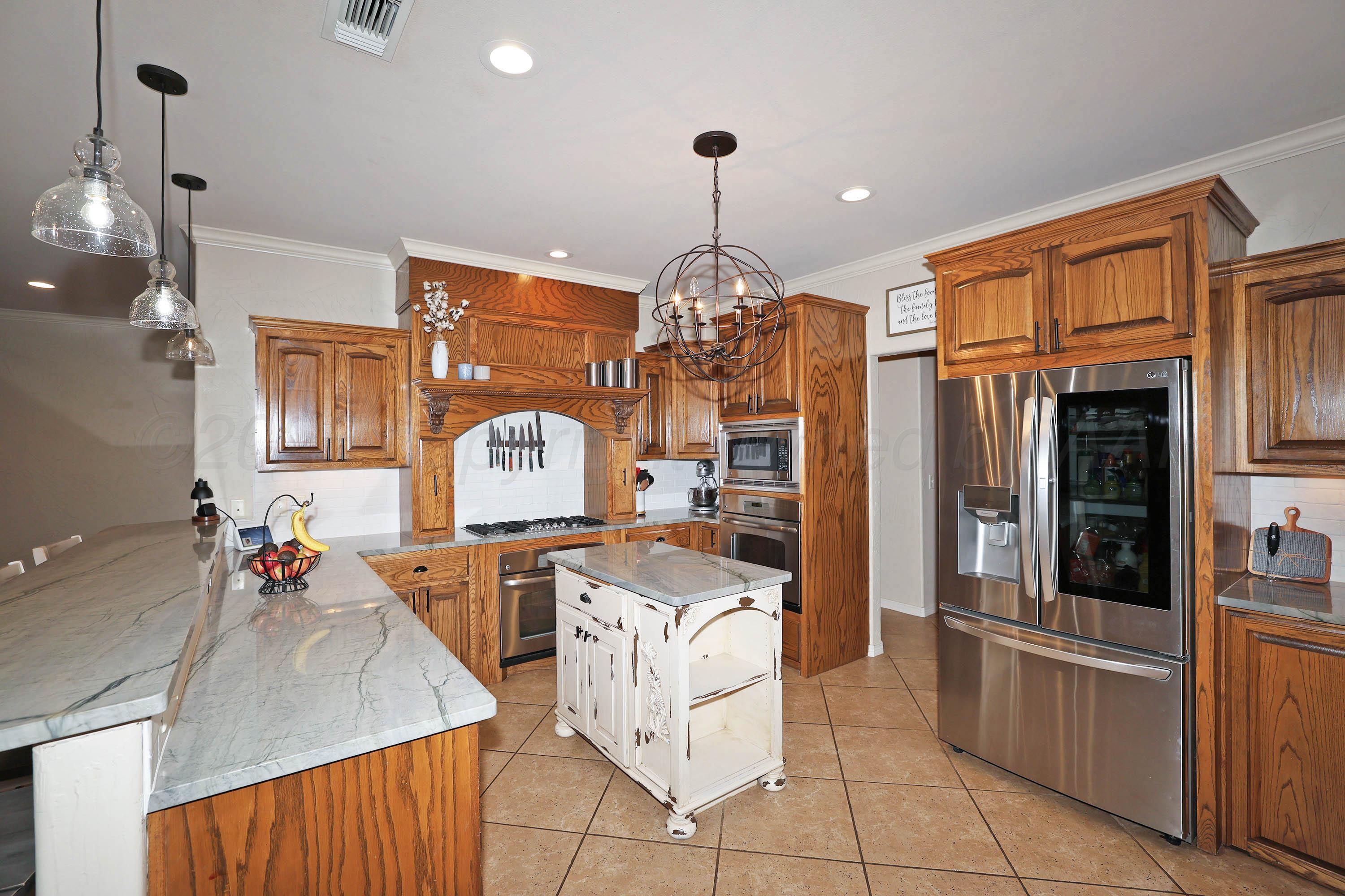 9220 Greyhawk Road Amarillo, TX 79119 - Photo 8 of 50 a kitchen with stainless steel appliances granite countertop a stove oven and a refrigerator