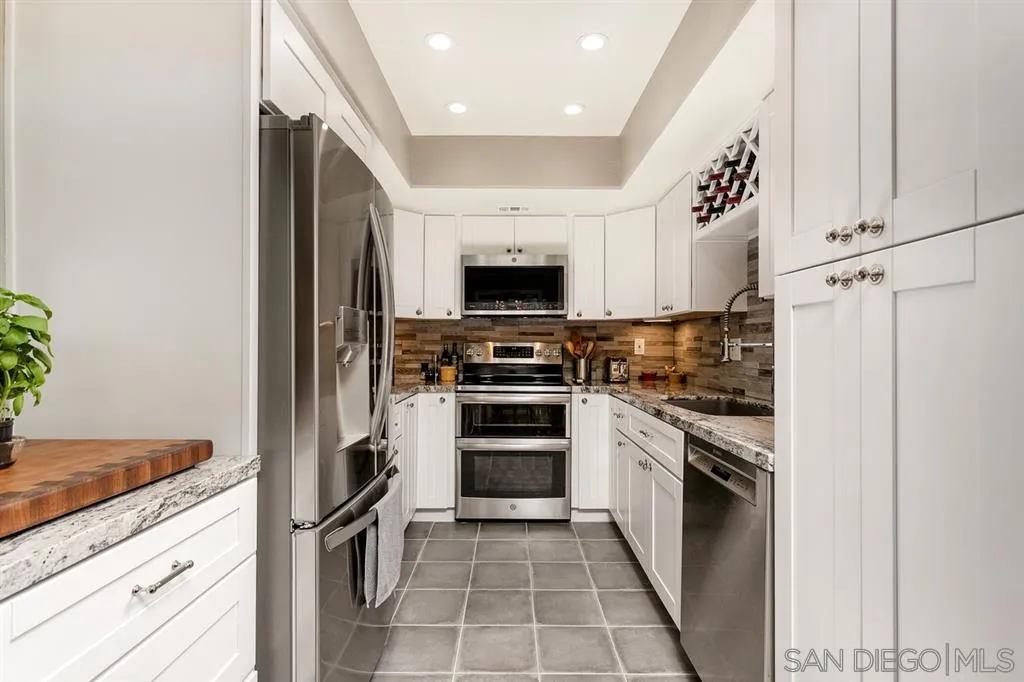 13955 Midland Road Poway, CA 92064 - Photo 10 of 25 a kitchen with granite countertop a refrigerator and a stove top oven