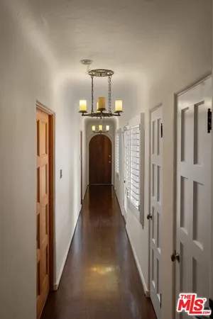 a view of a livingroom with wooden floor and a chandelier