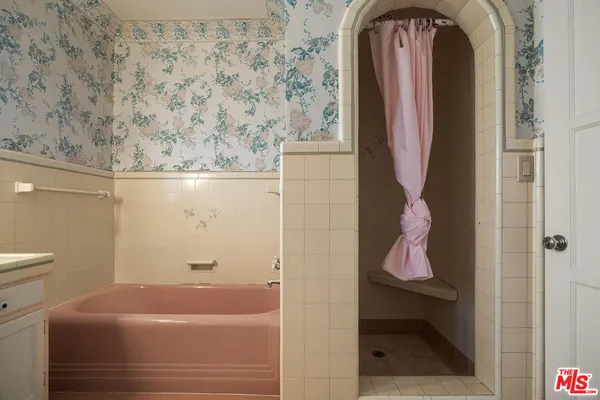 an empty room with wooden floor cabinet and windows