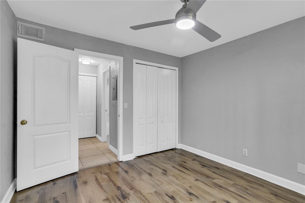 209 Red Cedar Place, Unit 209 Brandon, FL 33510 - Photo 15 of 56 an empty room with wooden floor cabinet and a ceiling fan