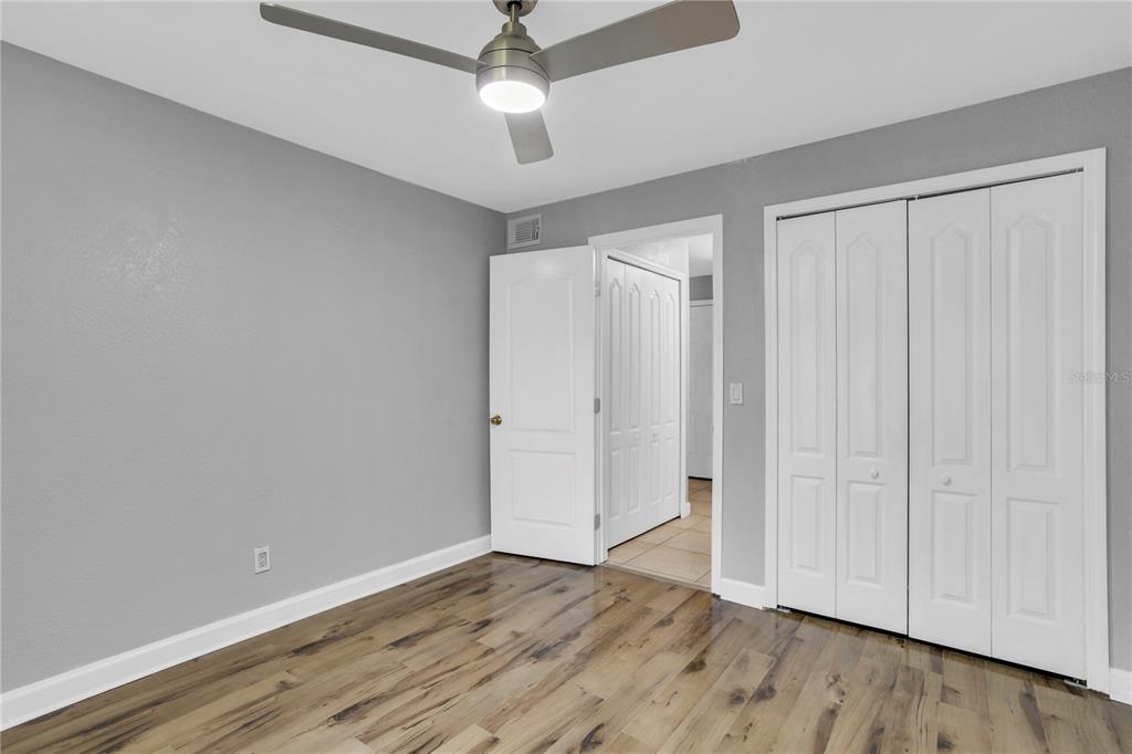209 Red Cedar Place, Unit 209 Brandon, FL 33510 - Photo 16 of 56 an empty room with wooden floor closet fan and windows