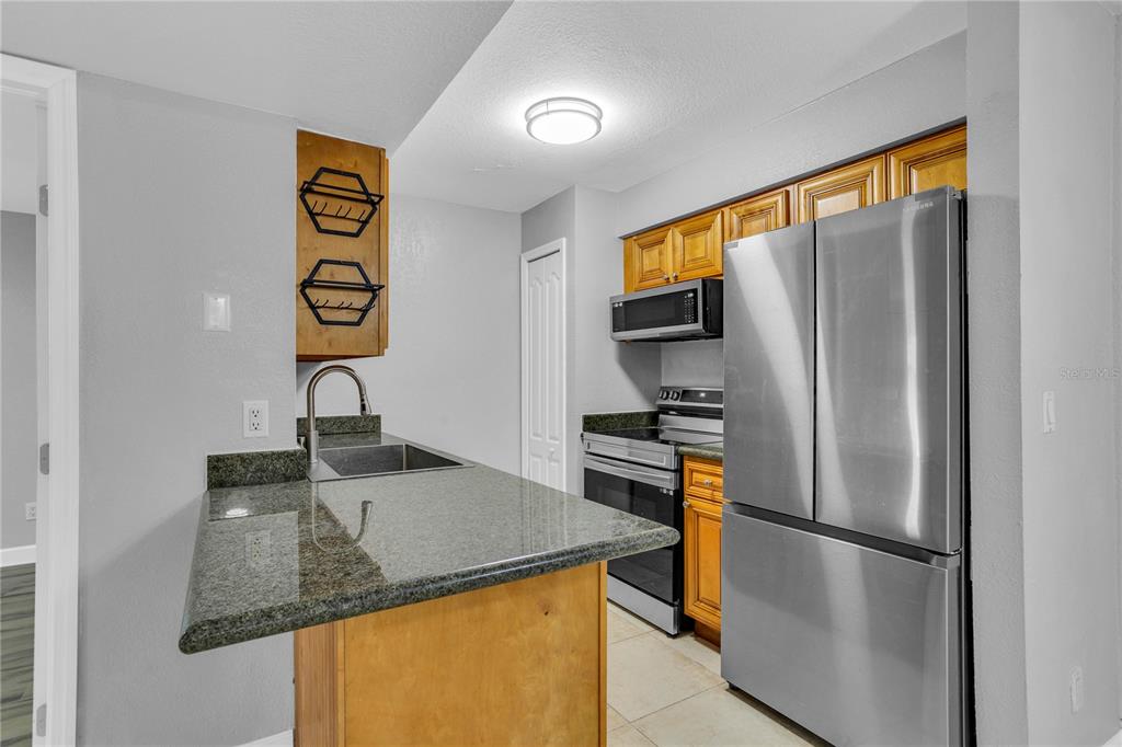209 Red Cedar Place, Unit 209 Brandon, FL 33510 - Photo 2 of 56 a kitchen with a refrigerator and a sink