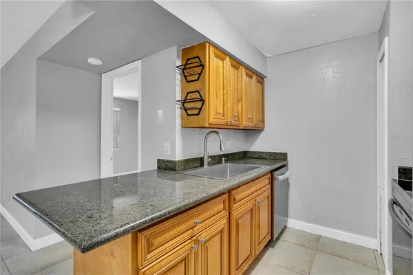 a view of a kitchen with stainless steel appliances granite countertop a stove and a refrigerator