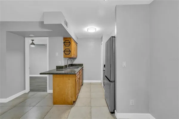 an empty room with wooden floor cabinet and a ceiling fan