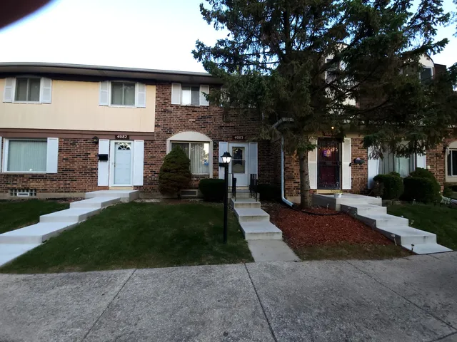 a front view of a house with a yard and trees