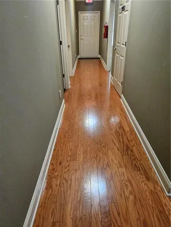 a view of a hallway with wooden floor