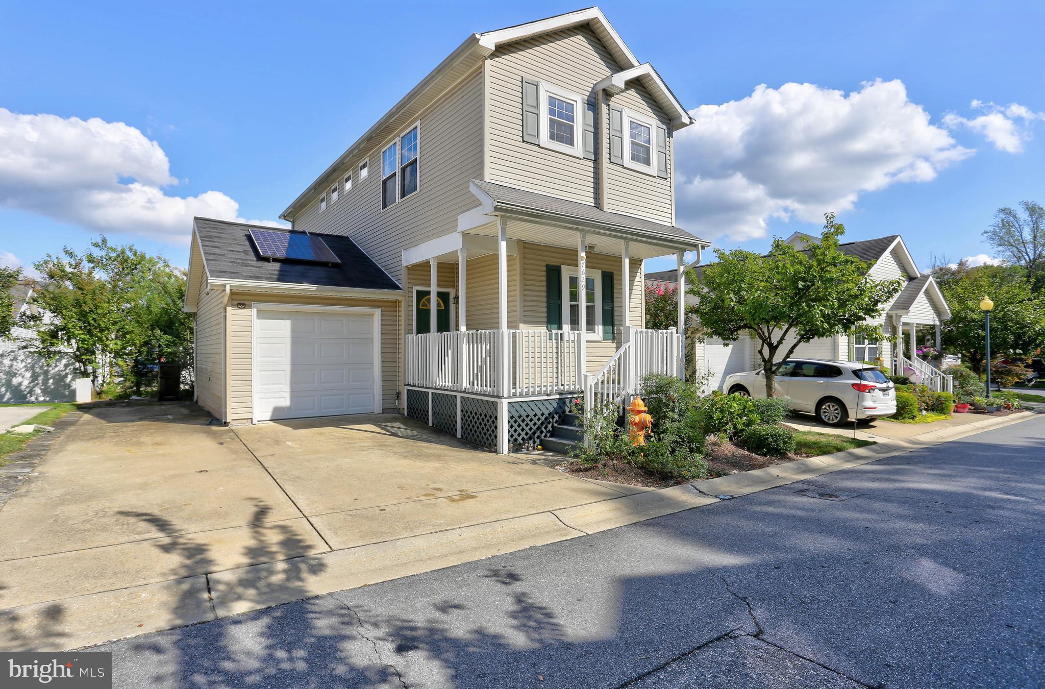 a view of a white house with a yard and plants