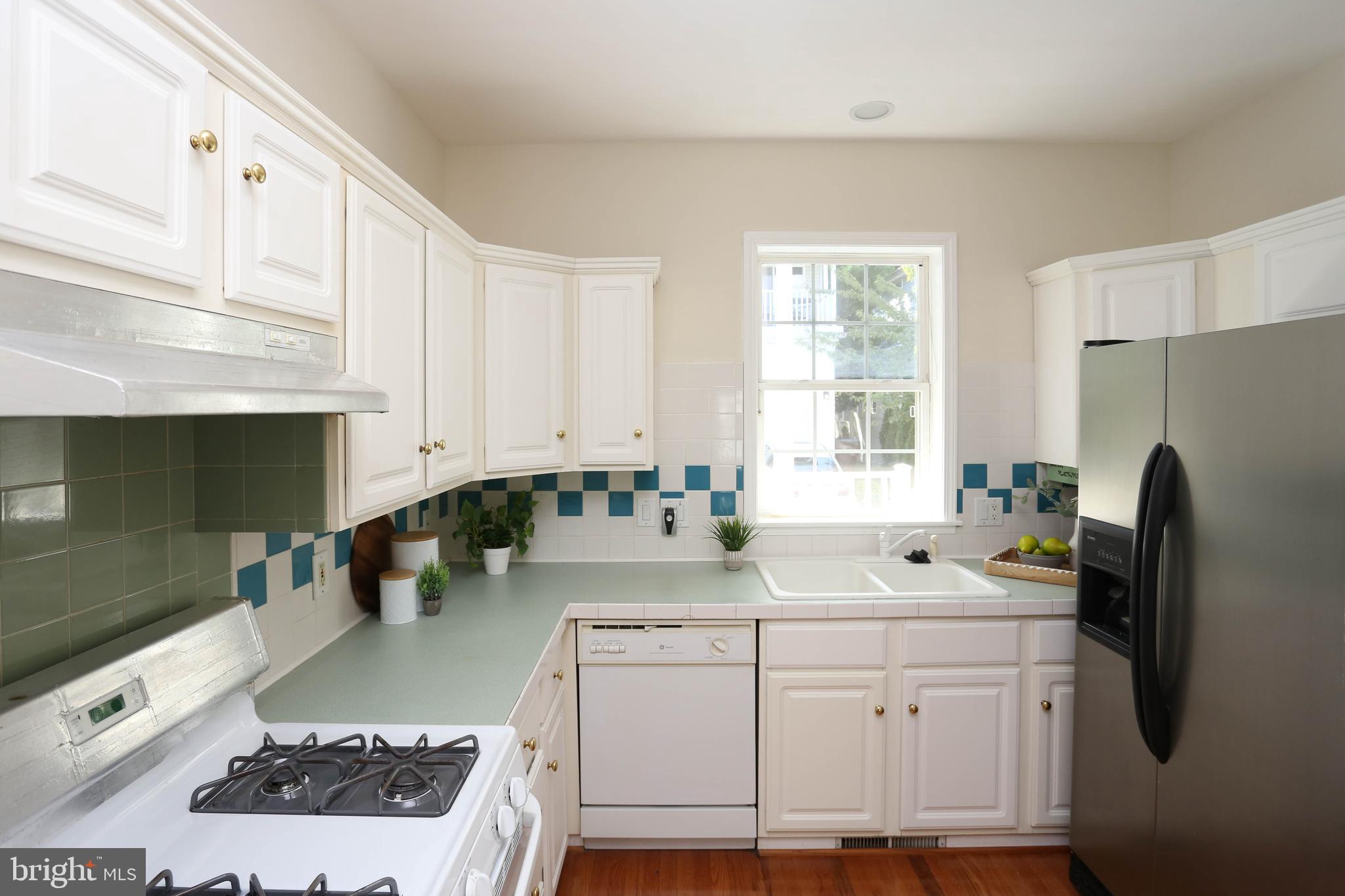 7629 Bluff Point Lane Elkridge, MD 21075 - Photo 4 of 31 a kitchen with white cabinets and appliances