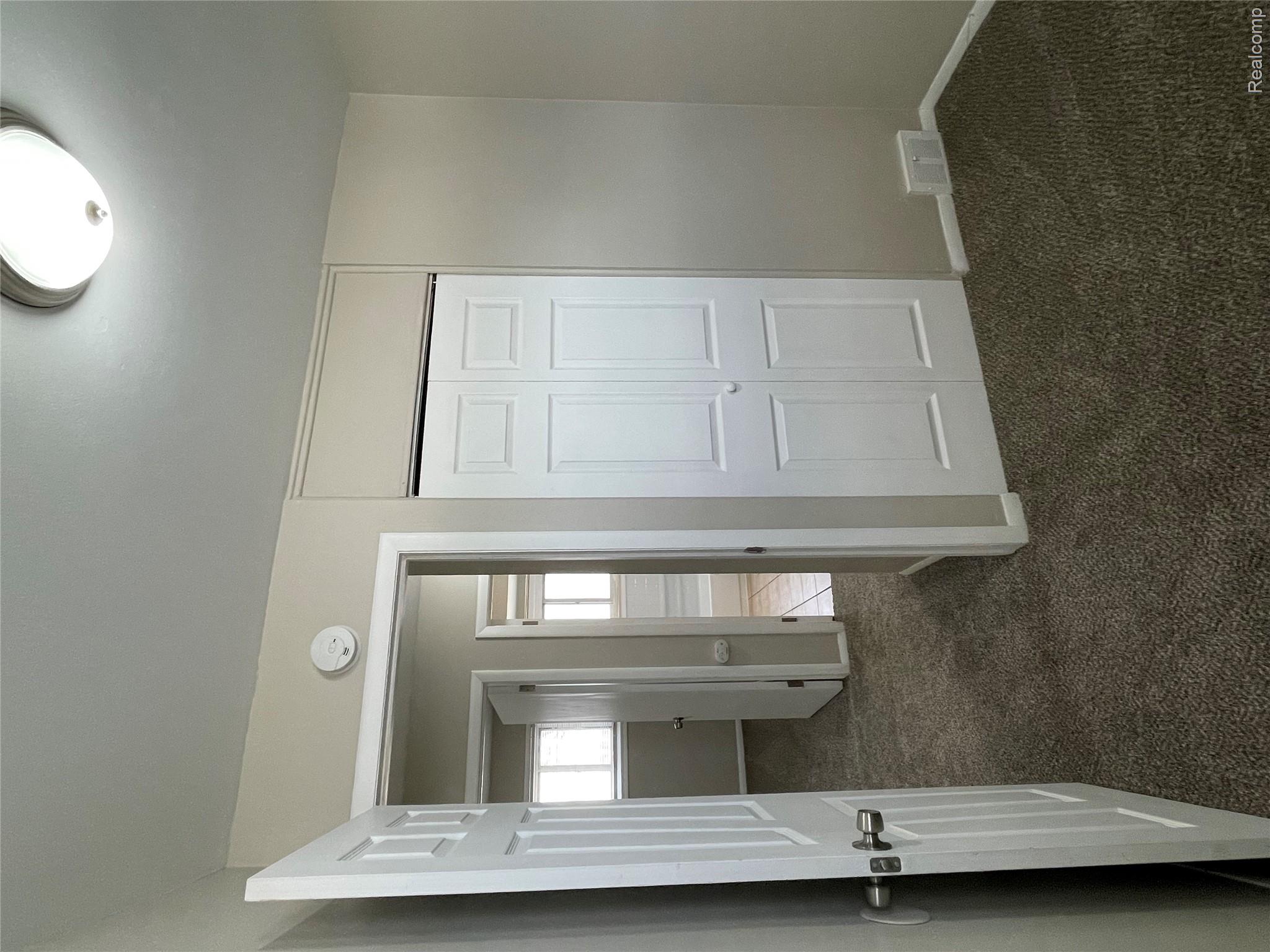 1173 Featherstone Road Pontiac, MI 48342 - Photo 12 of 23 Room featuring neutral tone walls, dark carpet, and white trim