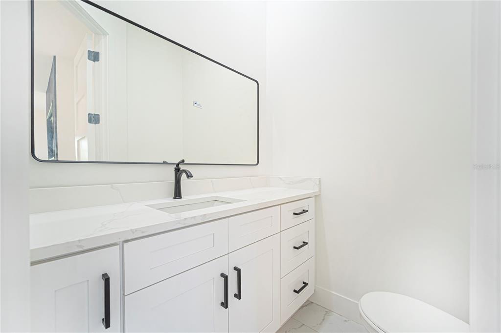 14080 Sydney Road Dover, FL 33527 - Photo 18 of 54 a bathroom with a toilet sink and mirror